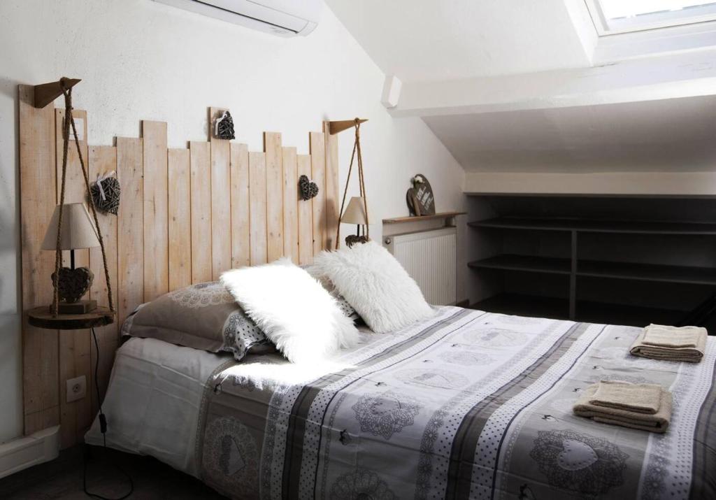 une chambre avec un grand lit avec une tête de lit en bois dans l'établissement Appartement cosy à Clermont-Ferrand 35 m² proche commodités, à Clermont-Ferrand
