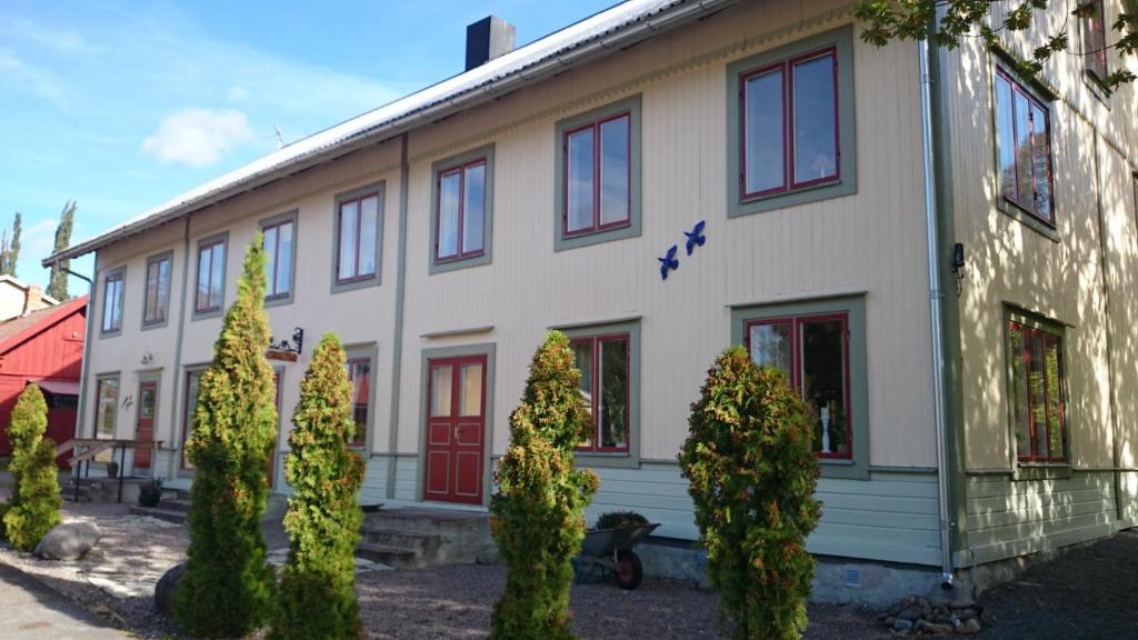 Manes Apartment في Undenäs: مبنى ابيض امامه اشجار