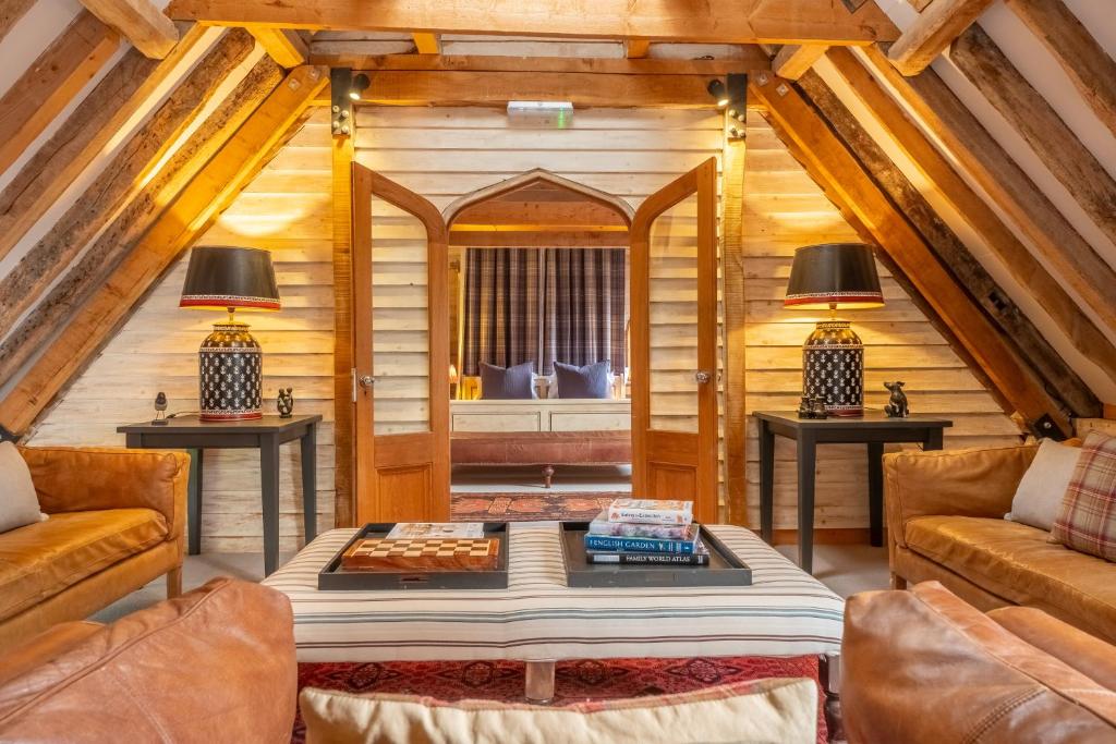 a living room with two couches and a table at Huge luxury loft cottage in historic country estate - Belchamp Hall Hayloft in Belchamp Otten