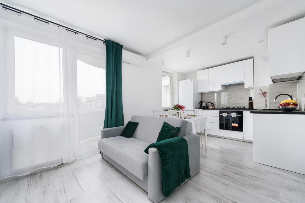 sala de estar blanca con sofá y cocina en Bella Casa Premium Apartment - 117A Kobierzynska, en Cracovia