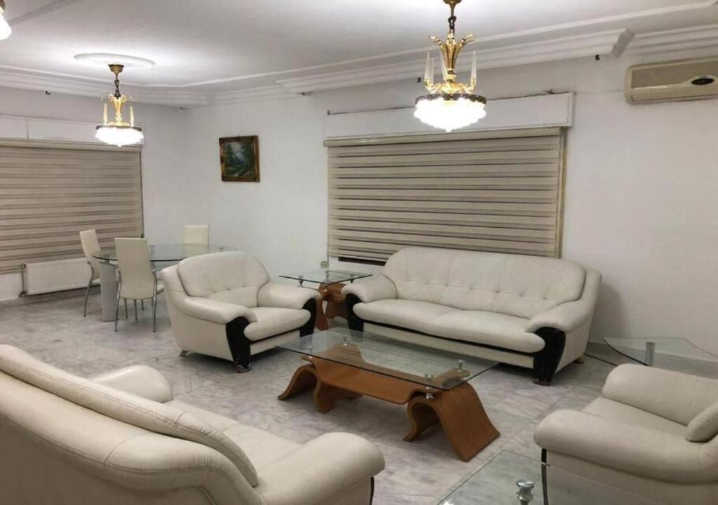 sala de estar con sofás, mesa y sillas en شقة مفروشة 4غرف نوم شارع الجامعة, en Amán