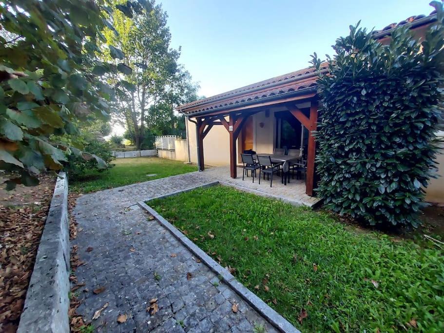 a house with a patio with a table and chairs at Appart*Résidence piscine*Parking*3mn Centre Sarlat in Sarlat-la-Canéda