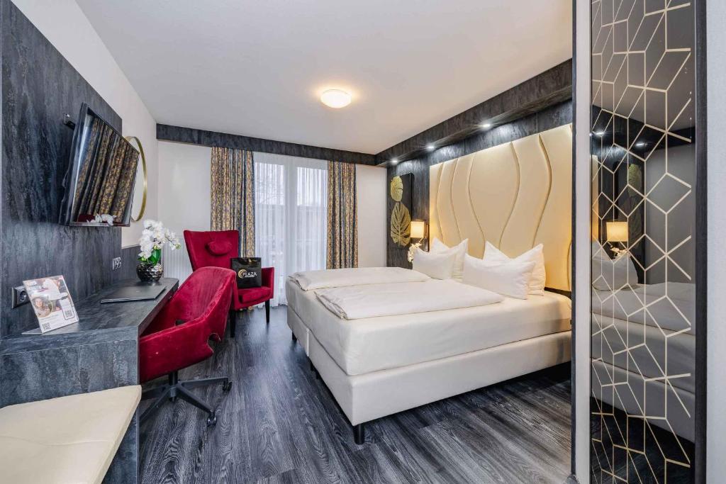 a hotel room with a bed and a red chair at PLAZA INN Köln Pulheim in Pulheim