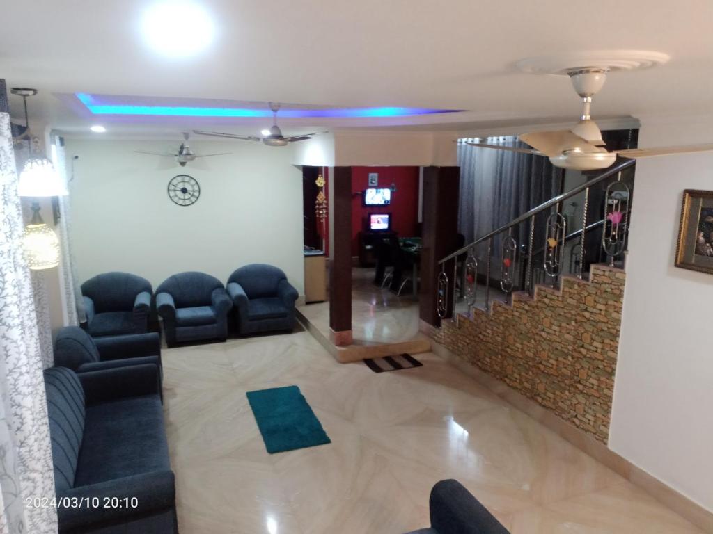 a living room with couches and a stair case at LOZZY HOMESTAY in Guwahati