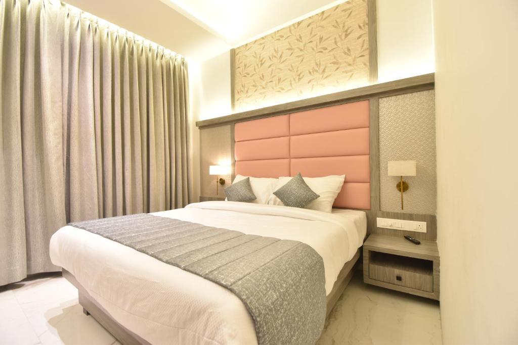 sypialnia z dużym łóżkiem z różowym zagłówkiem w obiekcie La Dhalia By Glitz Hotels w mieście Thane