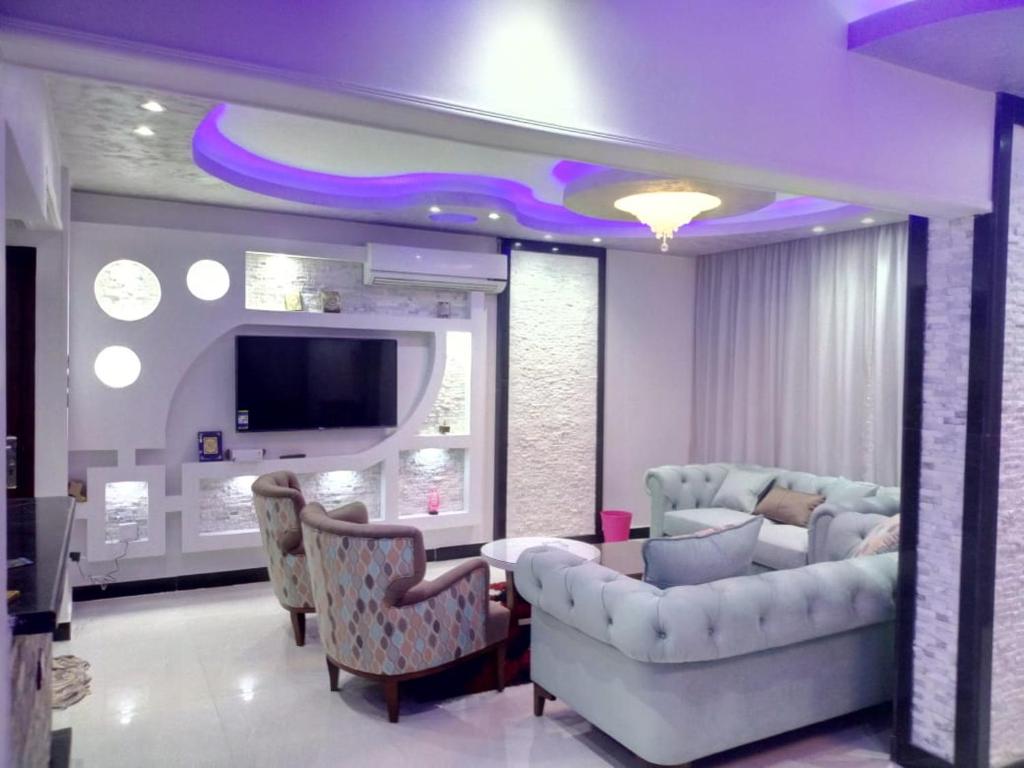 ein Wohnzimmer mit einem Sofa und einem TV in der Unterkunft مساكن شيراتون المطار in Kairo