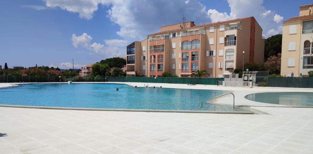 une grande piscine devant un immeuble dans l'établissement Cosy family cocoon with beautiful loggia, à Fréjus