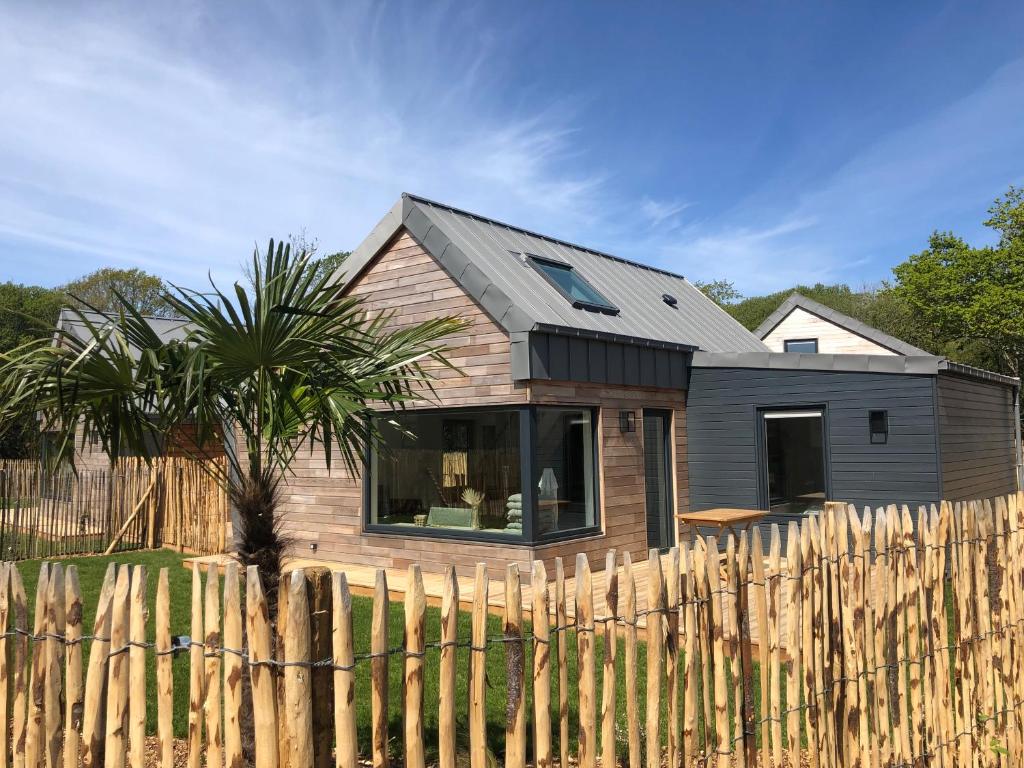 une petite maison derrière une clôture en bois dans l'établissement La cabine du bout du monde avec Mezzanine - Ile de Sein - votre maison de vacances de haut standing - PL03, à Crozon