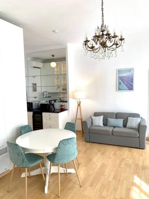 un salon avec une table, des chaises et un canapé dans l'établissement Saint Philippe - T3 près de la plage, à Nice