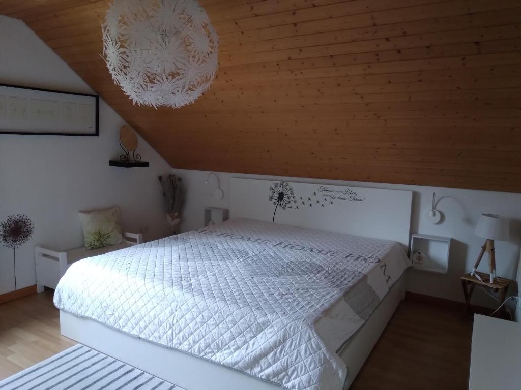 1 dormitorio con cama blanca y techo de madera en Ferienwohnung Monteurwohnung Pusteblume, en Duderstadt