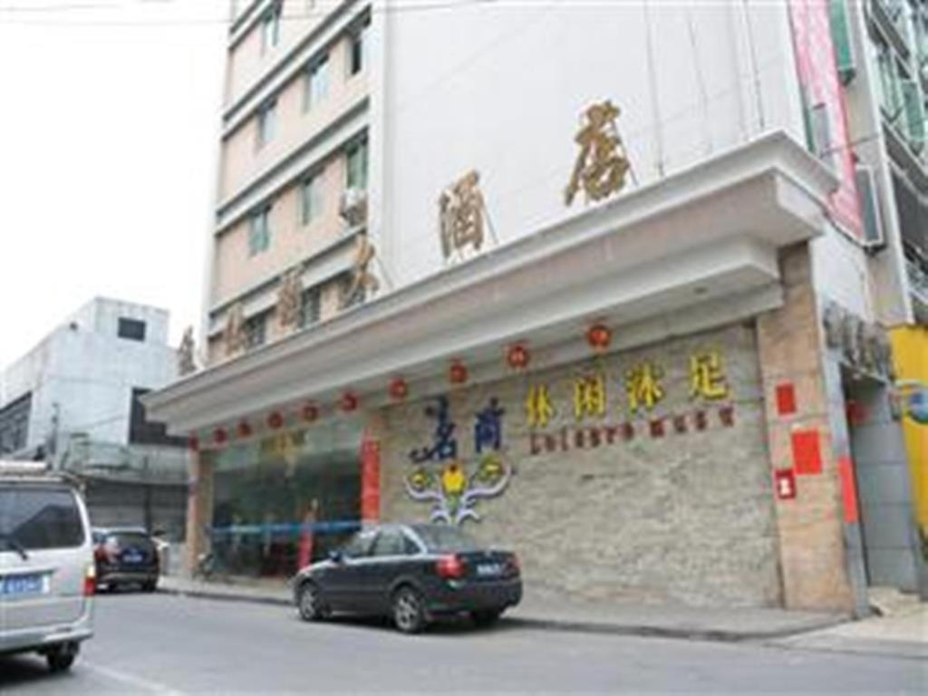un coche aparcado frente a una tienda en una calle en Yidun Hotel Foshan Luocun en Huanshi