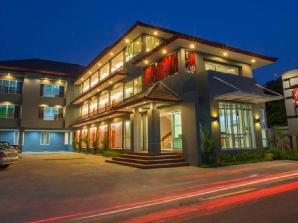 a large building with lights on in a street at Soontree House Hotel in Udon Thani