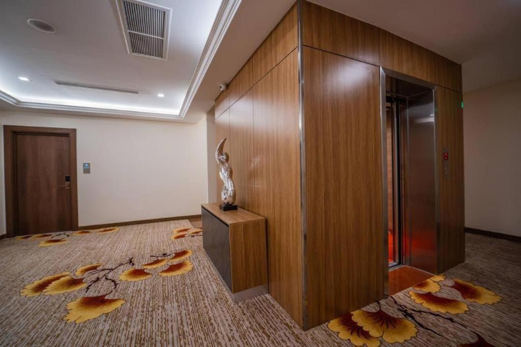 a room with a wall with leaves on the floor at Le President Hotel in Phnom Penh