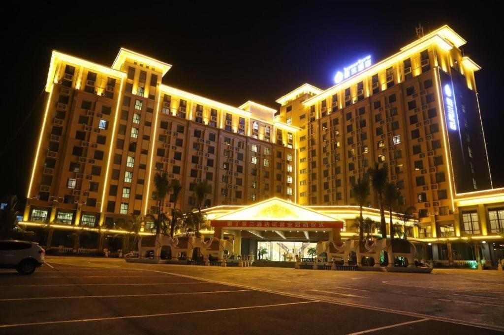 a large hotel with a parking lot at night at JING LAND HOTEL 