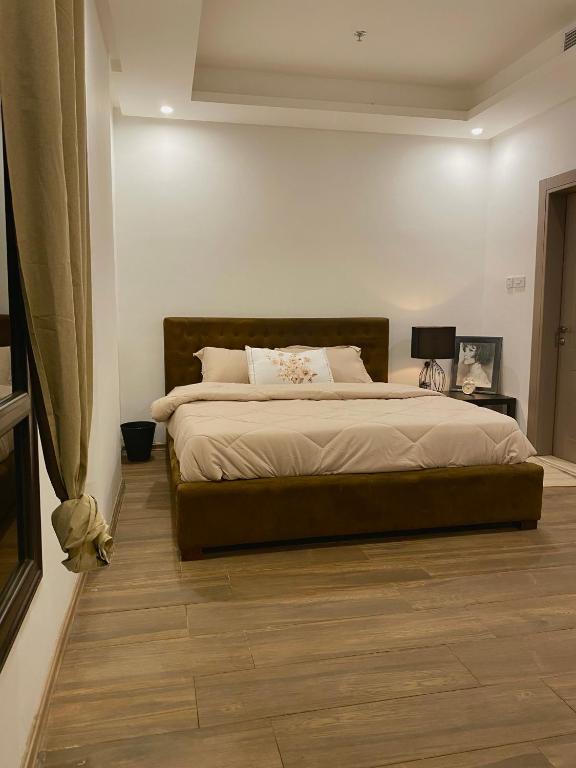 a bedroom with a large bed with a wooden floor at كويت in Kuwait