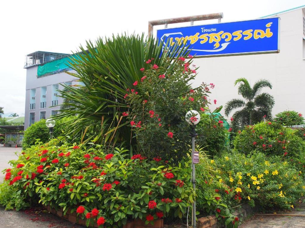 Phetsuwan Hotel في بيتشابون: مجموعة من الزهور أمام المبنى