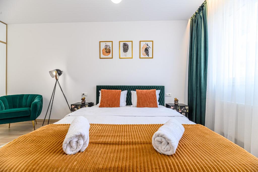 a bedroom with a bed with towels on it at B-Holiday Luxury Apartments in Braşov