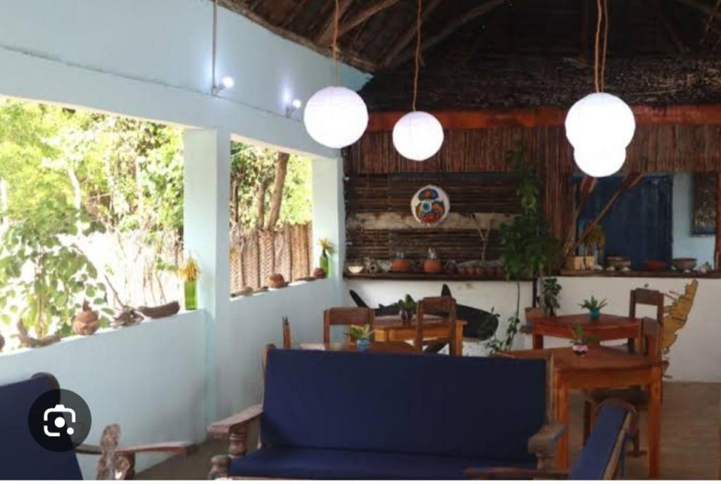 a living room with a blue couch and a table at Mangrove Beach Bungalows in Utende