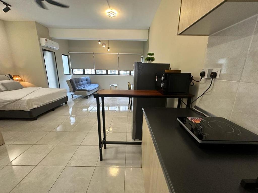 uma cozinha e sala de estar com uma mesa e um sofá em Cozy Homely Studio @ Youth City Residence Nilai em Nilai