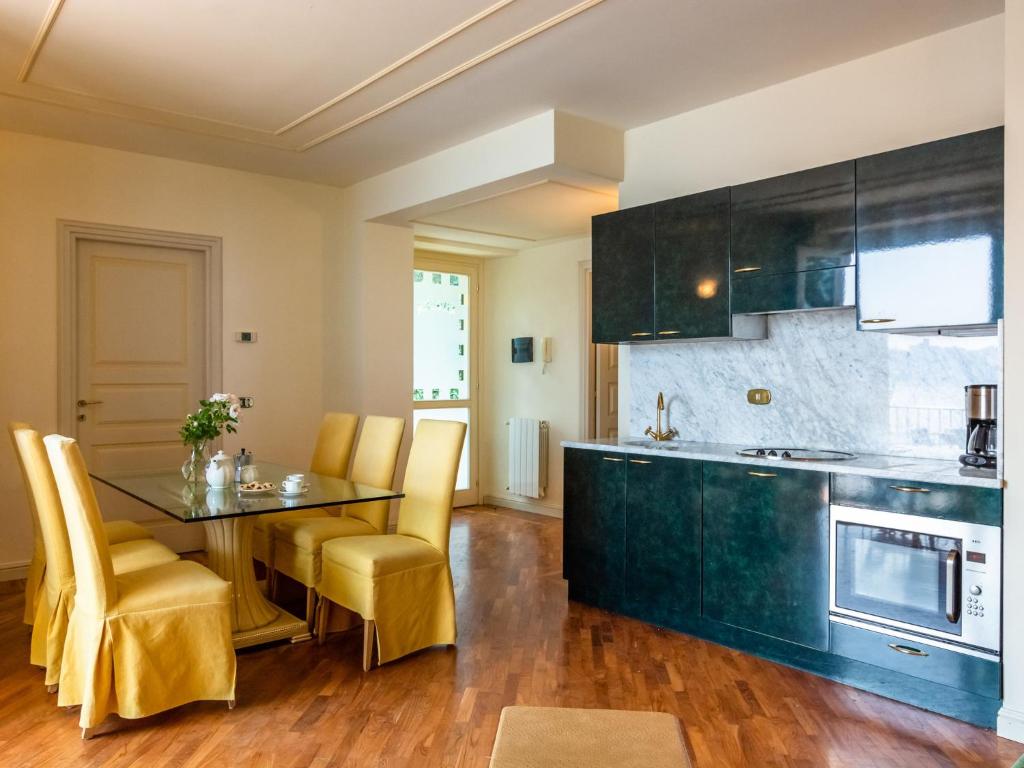 a kitchen with a table and yellow chairs in a room at Residence Villa Greta in Meina