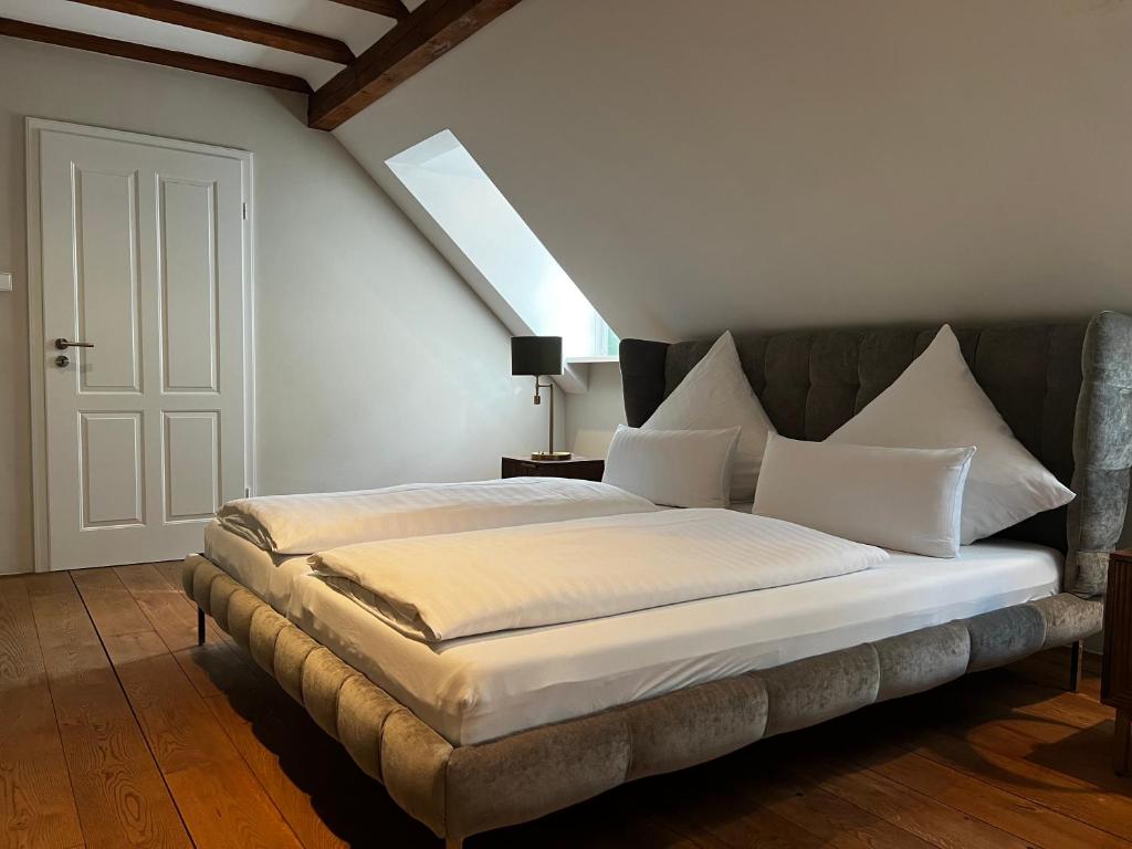 una camera da letto con un grande letto con cuscini bianchi di Hofgut Holzmuhle a Germersheim