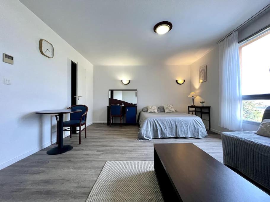 een slaapkamer met een bed, een tafel en een bank bij Zen studio ※ parking - piscine in Carcassonne