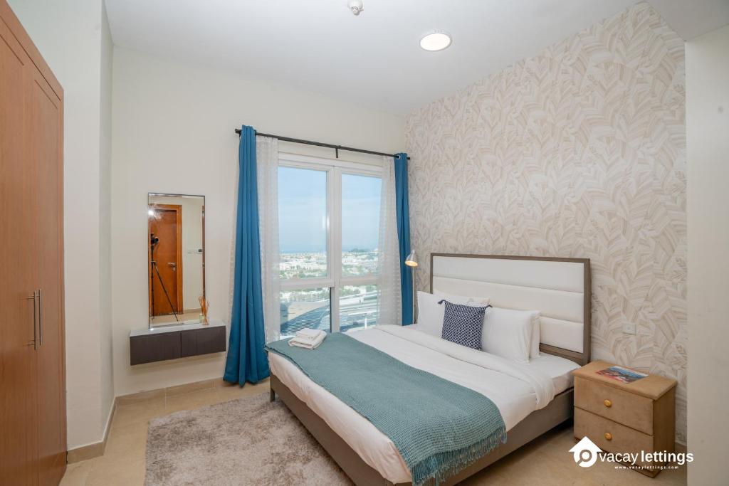 a bedroom with a large bed and a window at Tecom-Barsha Heights Retreat 2BR Stroll to Metro in Dubai