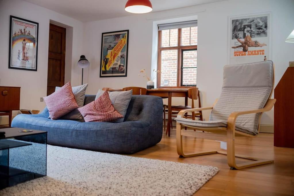un soggiorno con divano blu e sedia di Spacious Grade II Listed Flint Cottage Sleeps 2 a Norwich