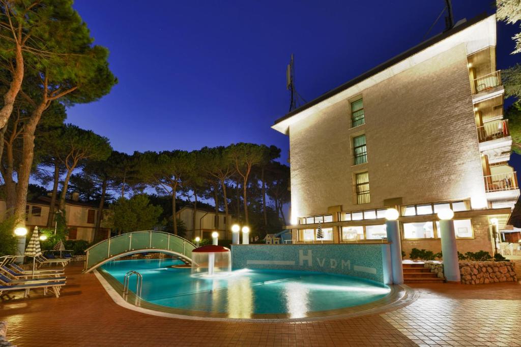 a swimming pool in front of a hotel at night at Hotel Vina De Mar in Lignano Sabbiadoro