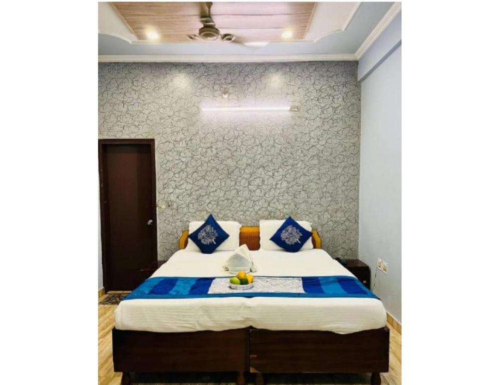 a bedroom with a large bed with blue pillows at Hotel Kamesh Hut, Varanasi in Varanasi