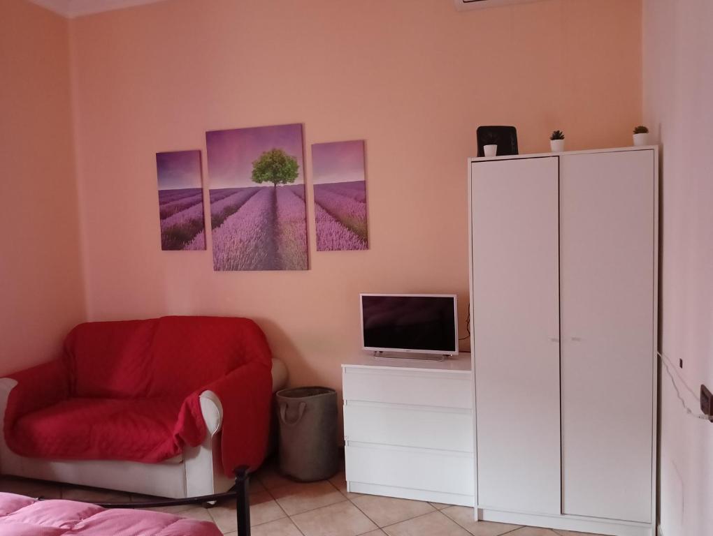 ボローニャにあるHome Sweet Homeの赤い椅子と木の壁が備わるベッドルーム1室