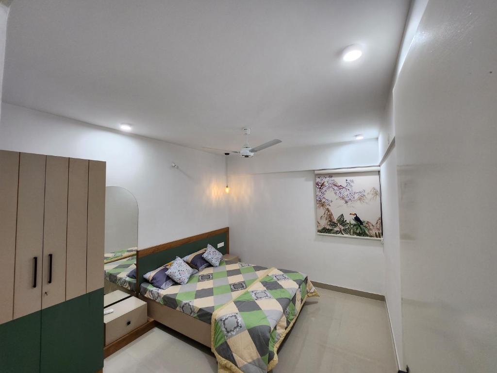 1 dormitorio con 1 cama y una pintura en la pared en Anandi Service Apartment, en Pune