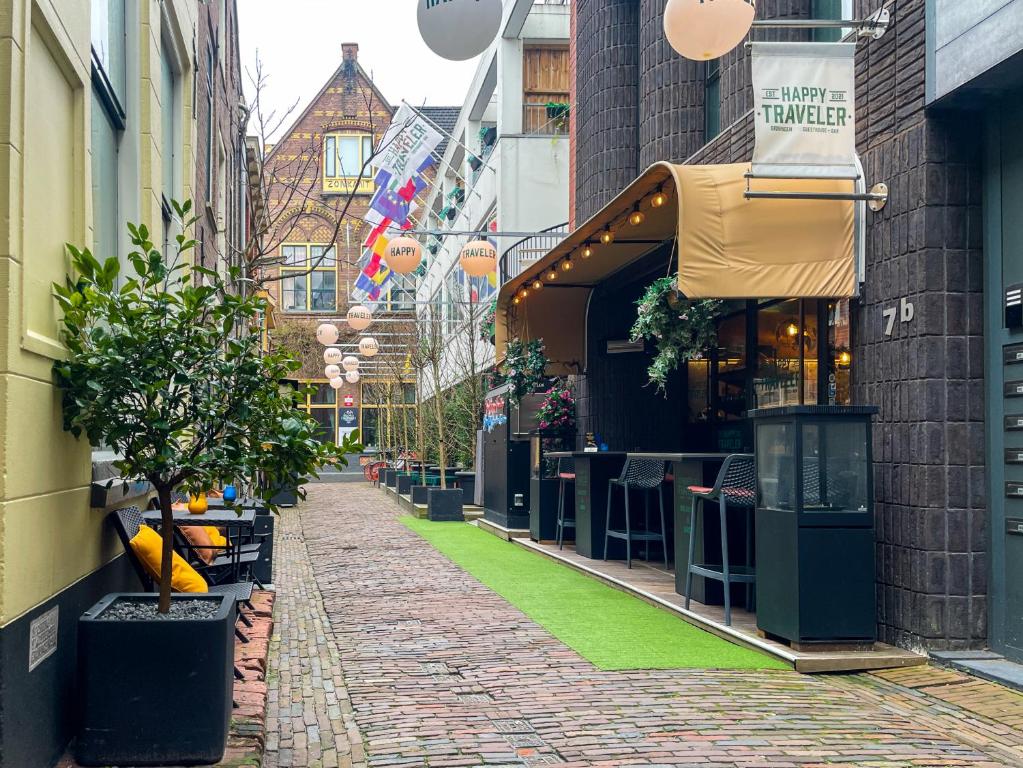 eine Kopfsteinpflasterstraße in einer Stadt mit einem Geschäft in der Unterkunft Hotel The Happy Traveler in Groningen