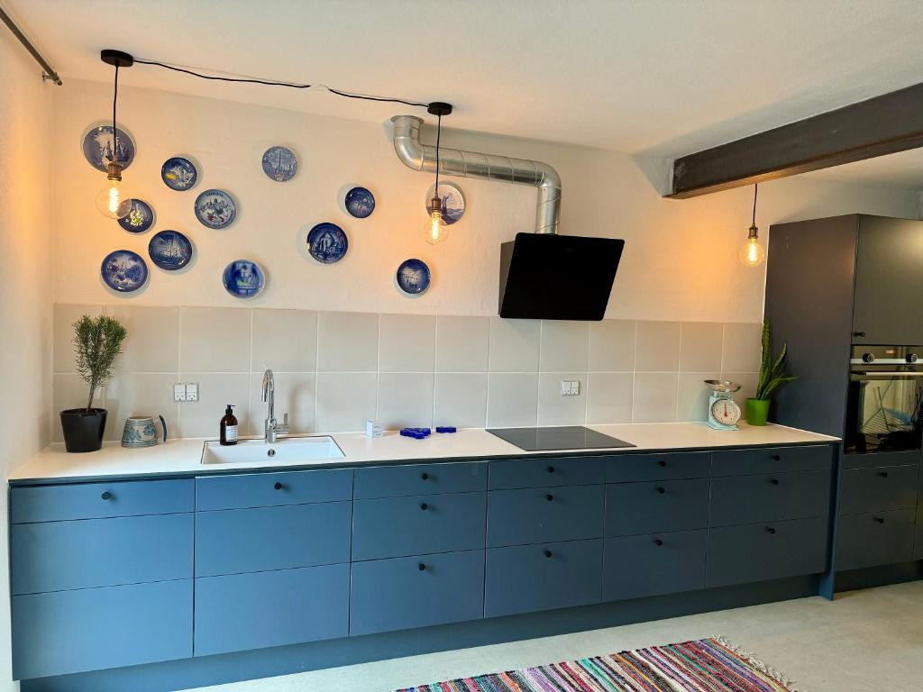 uma cozinha com pratos azuis e brancos na parede em Ellens Have, lejlighed Beate em Ebeltoft