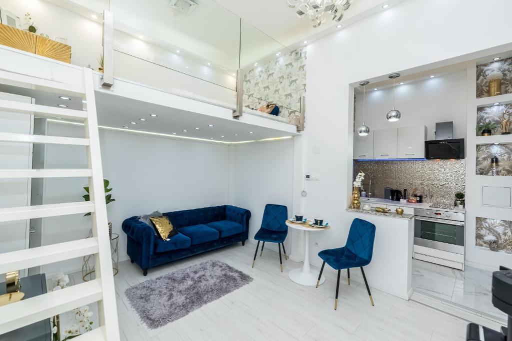 ein Wohnzimmer mit einem blauen Sofa und Stühlen in der Unterkunft Zichy Luxury Apartment in Budapest