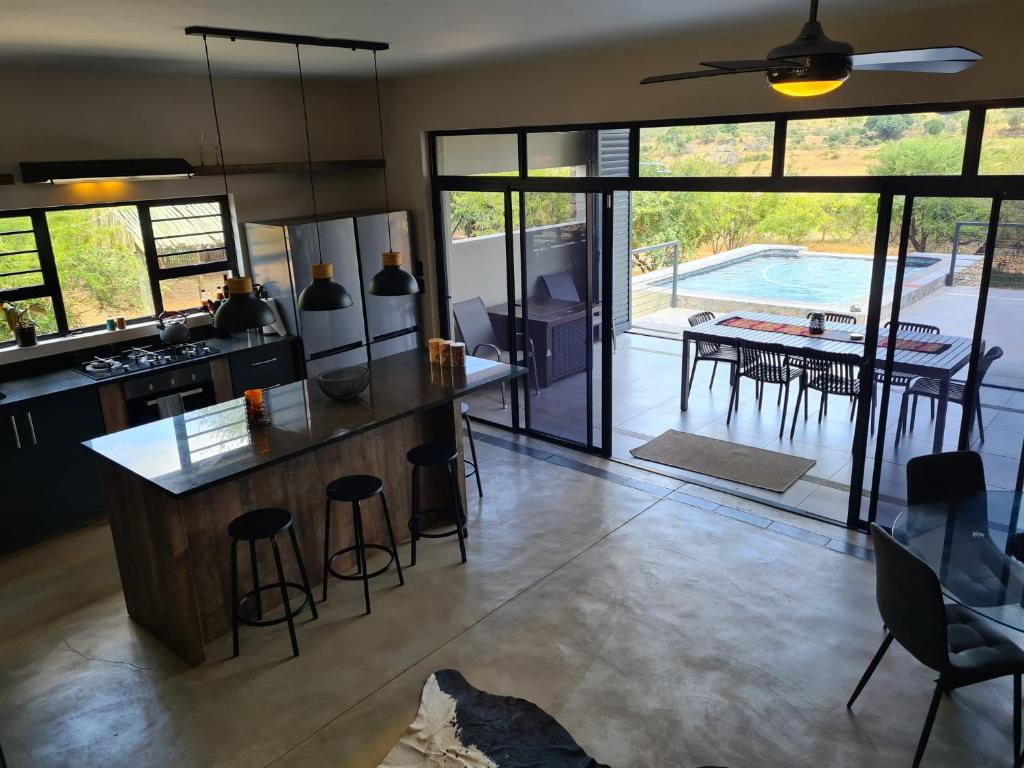 uma cozinha e sala de estar com mesa e cadeiras em Rosendal Kruger View Villa em Marloth Park