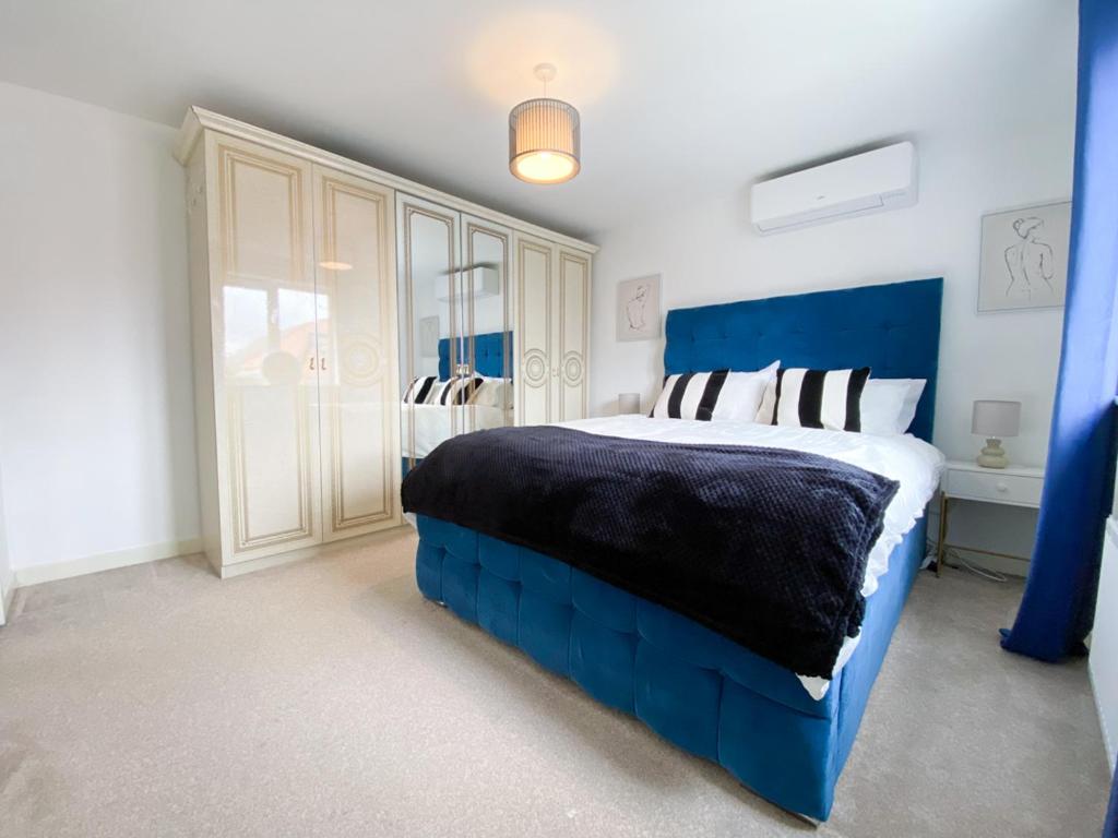 sypialnia z niebieskim łóżkiem z niebieskim zagłówkiem w obiekcie Spacious 4 Bed Peterborough House With Parking w mieście Peterborough