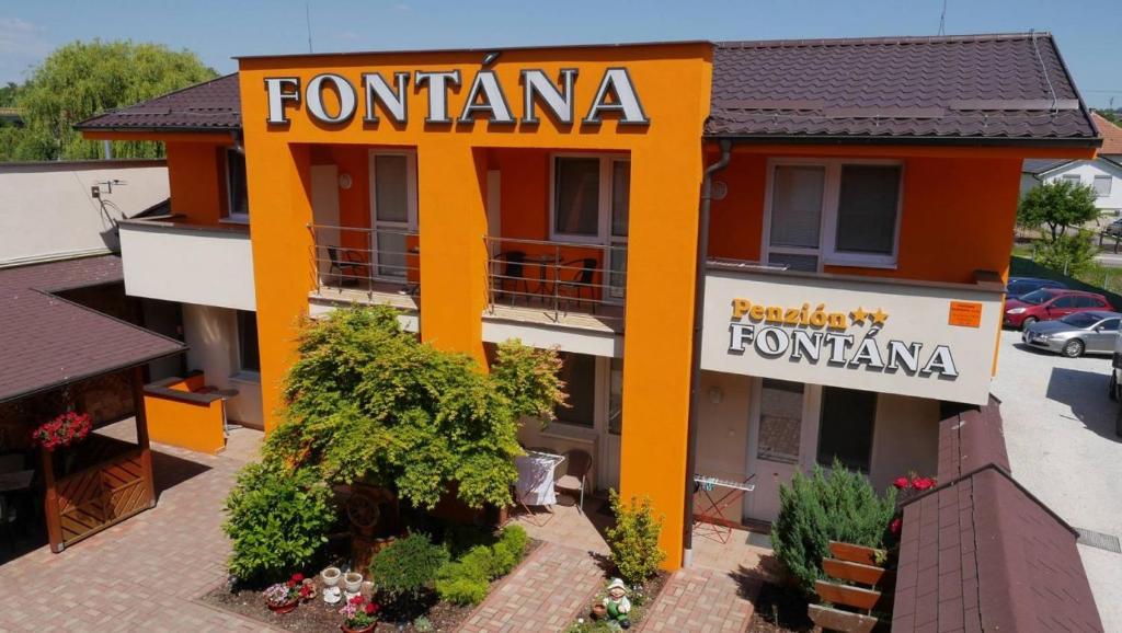 pomarańczowy budynek z tabliczką na restaurację w obiekcie Penzión FONTÁNA w mieście Podhájska