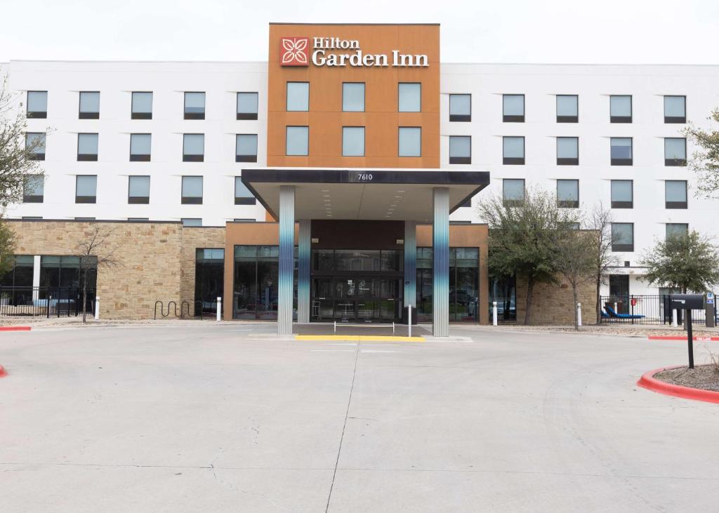 an empty parking lot in front of a building at Hilton Garden Inn Austin Airport in Austin