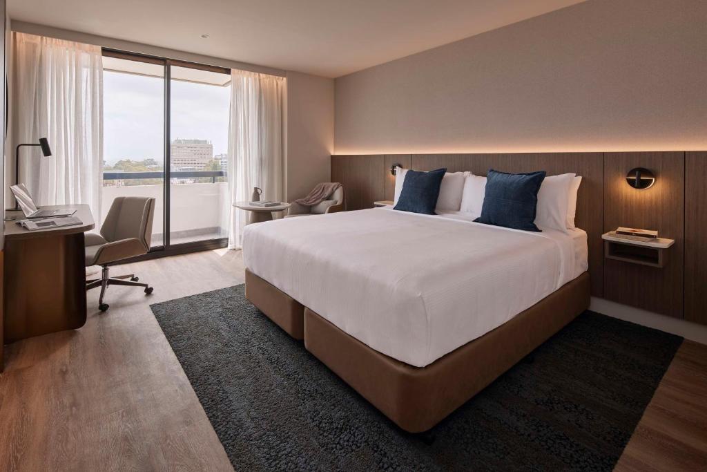 een hotelkamer met een groot bed en een bureau bij The Miller Hotel North Sydney in Sydney