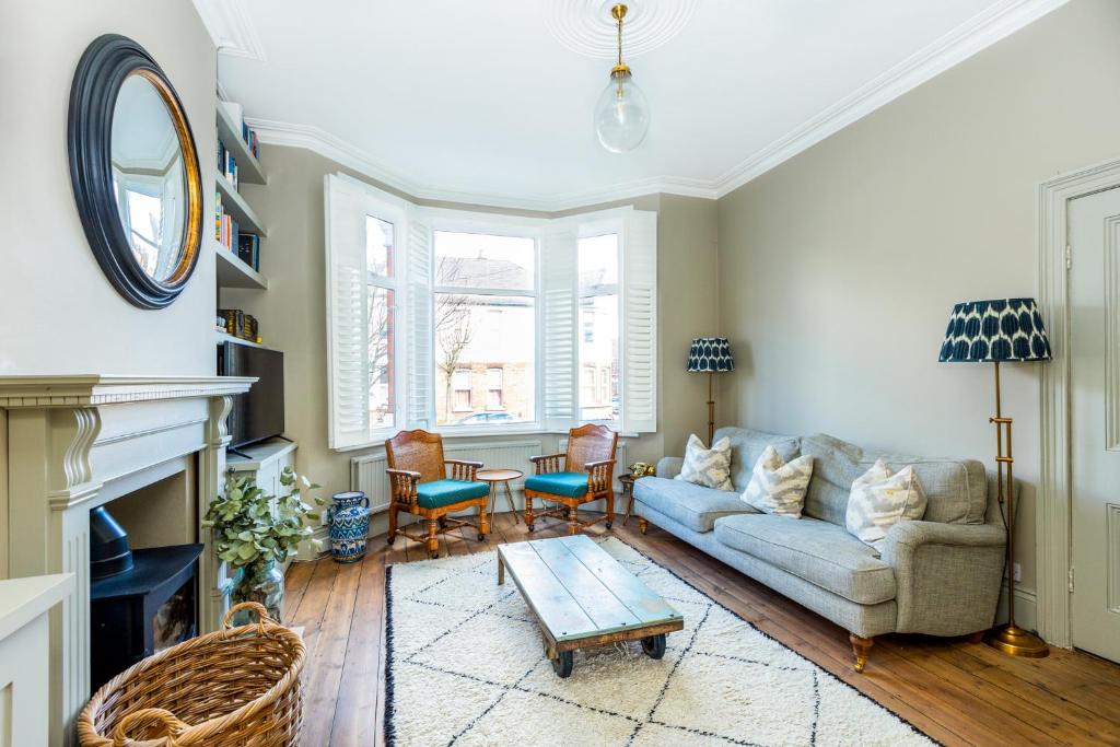 a living room with a couch and a table at Fantastic Edwardian 3BR House w/Gdn, Kensal Green in London