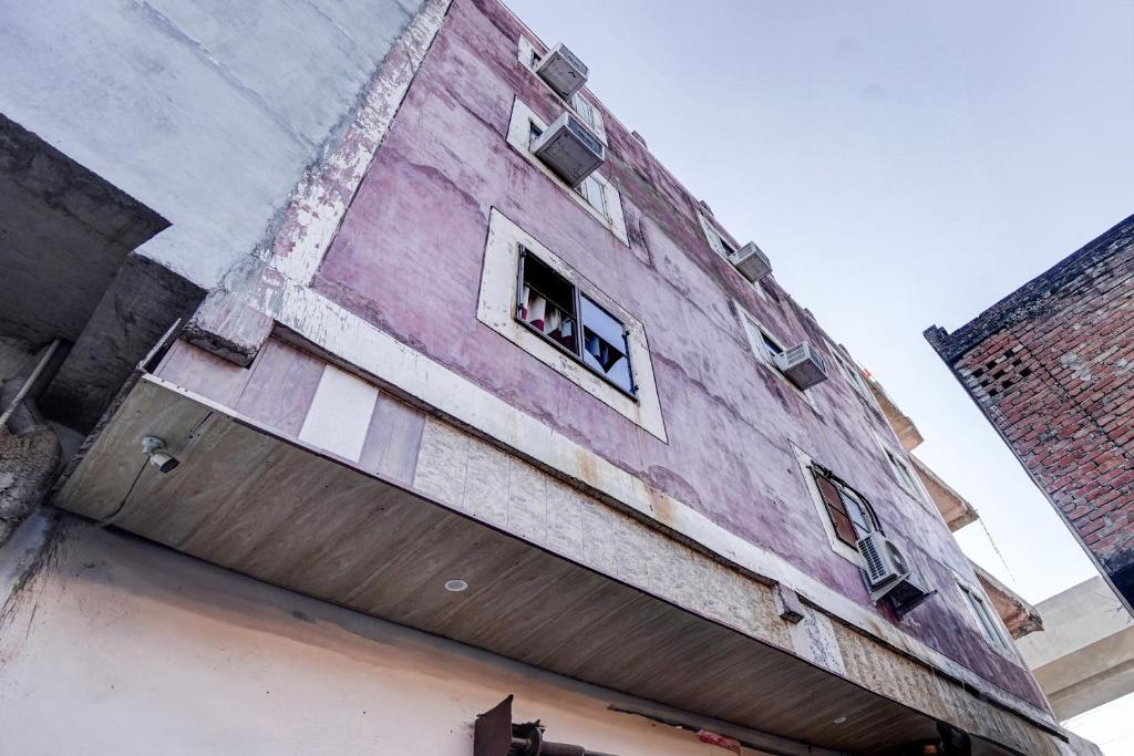 a building with a dog sticking its head out of a window at OYO Hotel Aryawart galaxy in Kānpur