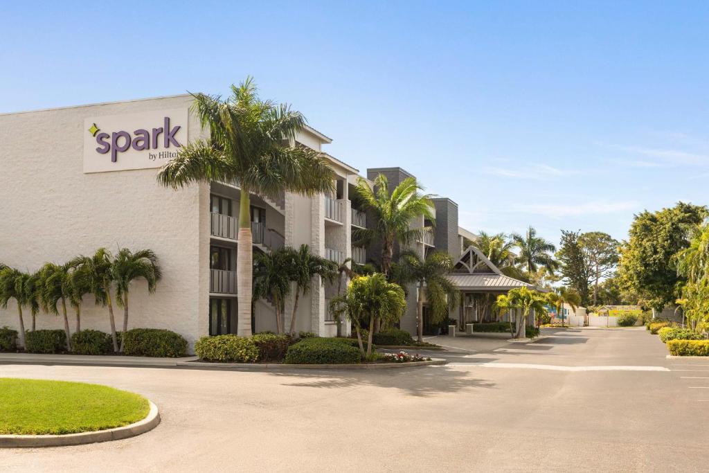 a resort with palm trees in front of a building at Spark by Hilton Sarasota Siesta Key Gateway in Sarasota