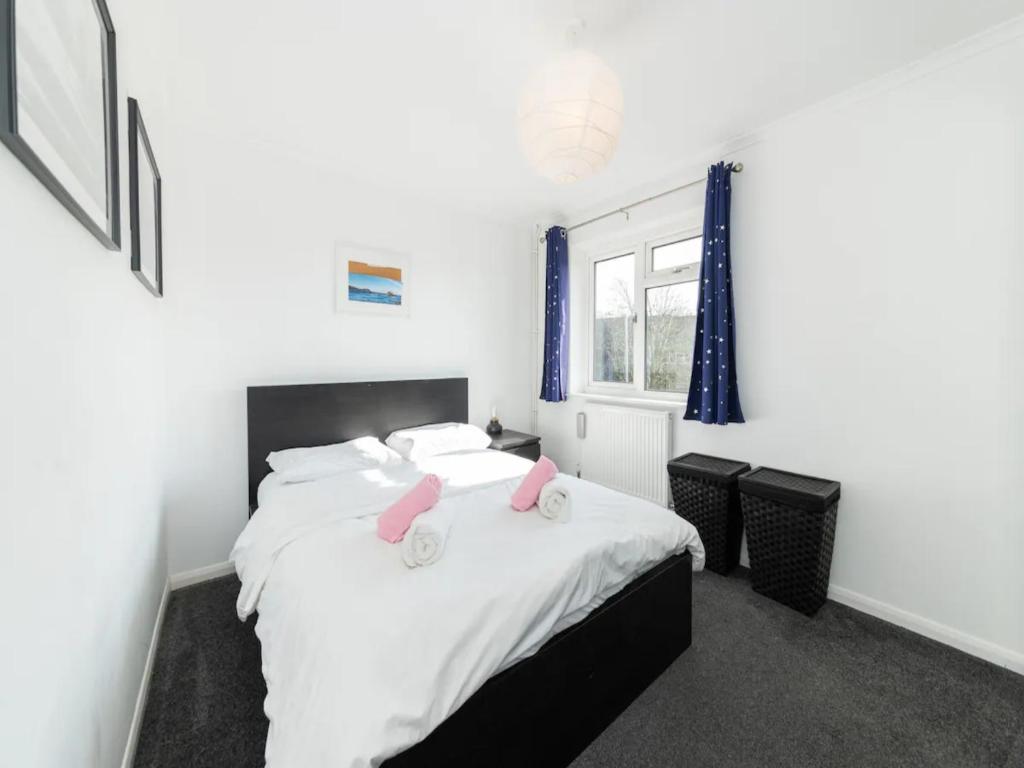 a bedroom with a bed with two pink towels on it at Pass the Keys Heart of Emmer Green with Stylish Interiors in Reading