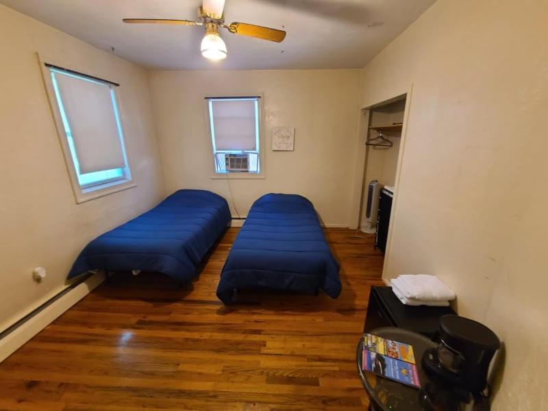 a room with two beds and a ceiling fan at GUEST HOUSE NEAR DOWTOWN BOSTON in Boston