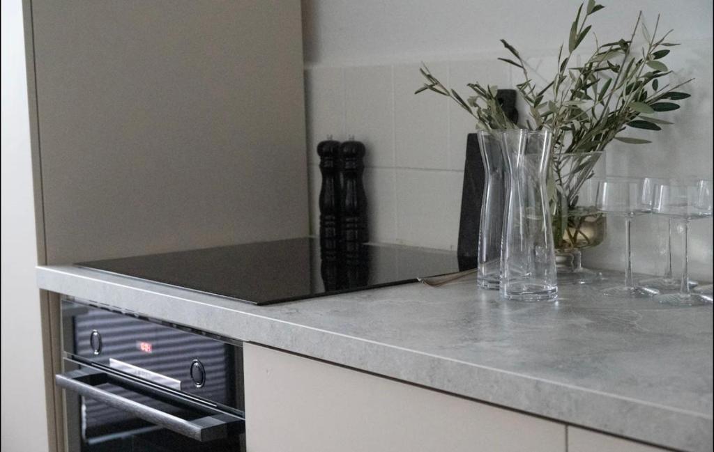 a kitchen counter with a vase with flowers in it at Modern, ruhig, gemütlich: 2 Zimmer Wohnung in bester Lage nahe Alster + Stadtpark in Hamburg