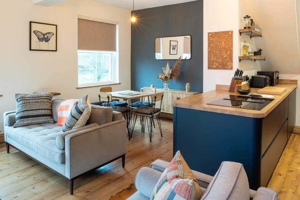 cocina y sala de estar con sofá y mesa en Stylish Quayside Apartment with River View en Norwich