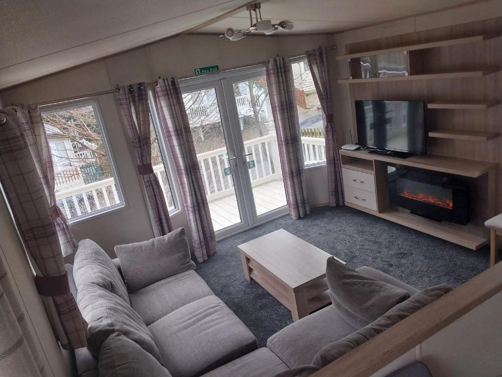 a living room with a couch and a tv at Bluebell corner - with small enclosed decking in Hastings