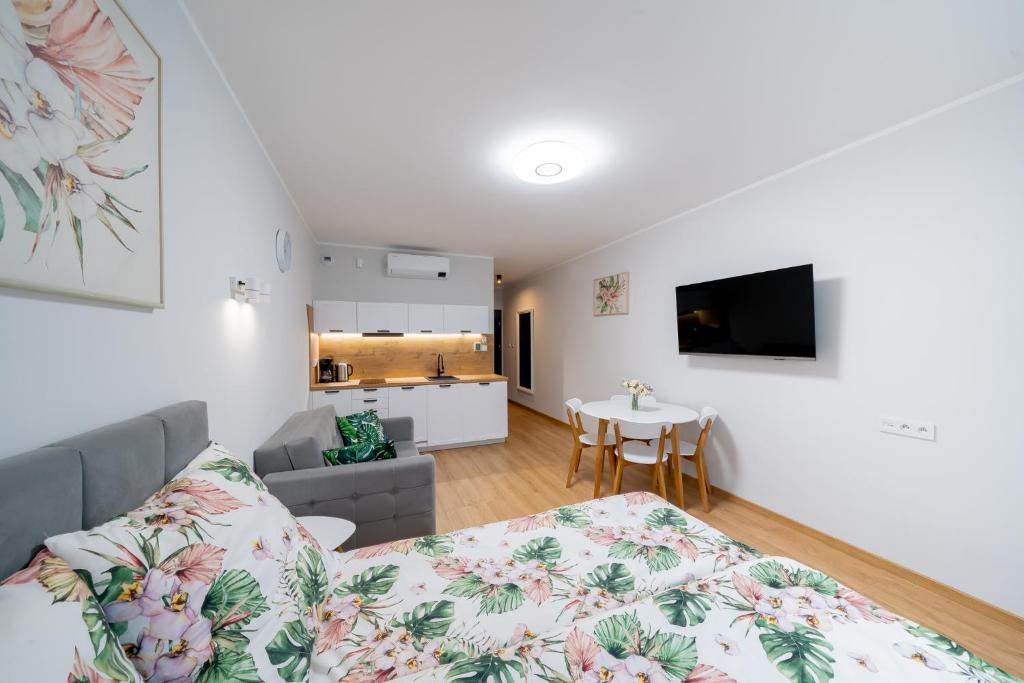 a living room with a bed and a kitchen at Lulu Apartments - Apartament FLORA z klimatyzacją - Solny Resort in Kołobrzeg