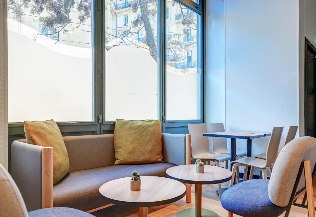 马赛B&B HOTEL Marseille Centre Vieux Port的一间设有桌子、沙发和窗户的等候室